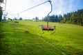 Emtpy chairlift in ski resort. Mountains and hills with in Summer with green trees