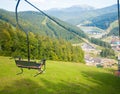 Emtpy chairlift in ski resort. Mountains and hills with in Summer with green trees Royalty Free Stock Photo