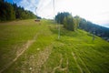 Emtpy chairlift in ski resort. Mountains and hills with in Summer with green trees Royalty Free Stock Photo