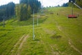 Emtpy chairlift in ski resort. Mountains and hills with in Summer with green trees Royalty Free Stock Photo