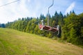 Emtpy chairlift in ski resort. Mountains and hills with in Summer with green trees Royalty Free Stock Photo