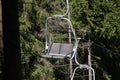 Emtpy double chair lift ride in sunny summer day. travel concept. backdrop of a dense forest. Mountains and hills in Summer with