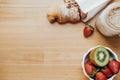 Emty space for text. Sweet breakfast with Coffee, croissant, strawberry, kiwi on a wooden table