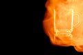 En empty glass mug for tea in the fire flames. Royalty Free Stock Photo