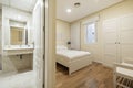 en-suite bedroom with bathroom with marble tiles, white wood