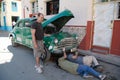 Classic car repair, Havana Cuba. Without a workshop and the right tools, the men try to weld a classic car. Royalty Free Stock Photo