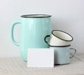 Enamel dishes and a white blank card on the table