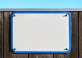 enamel, metal or pottery sign on a rustic wooden wall. blue frame, under a bright turquoise sky. Royalty Free Stock Photo