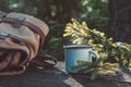 Enameled cup of coffee or tea, backpack of traveller on wooden board in forest outdoors