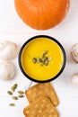 Enameled Mug of Tasty Pumpkin and Mushrooms Soup with Cream and Pumpkin Seeds Raw Mushrooms and Galette on White Wooden Background Royalty Free Stock Photo