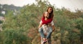 Young man lifted up girl on his back and carries her. Royalty Free Stock Photo