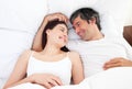 Enamored couple hugging lying in their bed