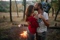 Enamored couple stands with guitar, hugs and kisses against back Royalty Free Stock Photo