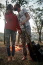 Enamored couple stands with guitar and kisses on picnic in fores Royalty Free Stock Photo