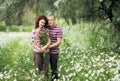 Enamored guy and girl in a green park with white daisies Royalty Free Stock Photo