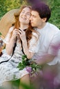 Happy married couple hugs while sitting on a green summer lawn in the park. Royalty Free Stock Photo