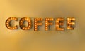 Encased lights in letter forms on a yellow wall reading coffee