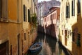Enchanted canal in the middle of Venice, small boat floats between historic houses in Italy Royalty Free Stock Photo