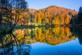 Enchanting autumn colors on the hills in the arboretum along the reservoir in the Aubonne, Switzerland reflect in the water and