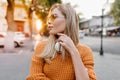 Enchanting fair-haired european woman looking around, trying to find friend. Outdoor portrait of elegant white girl