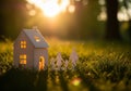 Enchanting miniature house bathed in golden hour sunlight amidst lush greenery and soft focus bokeh Royalty Free Stock Photo