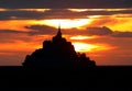 Enchanting sunset with fiery sky with orange and red clouds and Mont Saint Michel abbey Royalty Free Stock Photo