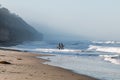 Two Male Surfers Carry Surfboards at Moonlight State Beach On Foggy Morning Royalty Free Stock Photo