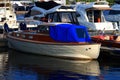 Enclosed motor boat with blue awning at the pier