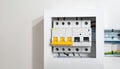 Open electrical panel with circuit breakers and yellow levers on a white wall Keywords: electrical panel, circuit Royalty Free Stock Photo