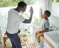 Encourage your child to follow good hygiene practices. High angle shot of a father giving his son a high five in a Royalty Free Stock Photo