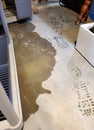 Floodwaters encroach across pale concrete floor next to wet boot prints Royalty Free Stock Photo