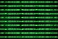 Encrypted binary ASCII computer code on black background. Green binary code computer