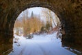 End of dark arched empty tunnel with views of mountain landscape in winter