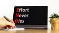 END effort never dies symbol. Concept words END effort never dies on beautiful black tablet. Beautiful white background.