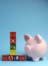 End of Financial Year sale message on building blocks with piggy bank - vertical with copy space. Royalty Free Stock Photo