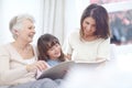 The end...a little girl sitting with her mother and grandmother and reading a book. Royalty Free Stock Photo
