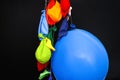 Some burst, deflated balloons and one inflated balloon hanging o