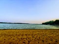 The end of summer empty beach with footprints in the sand at dusk. Royalty Free Stock Photo