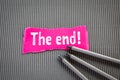 THE END. Text on torn, pink paper on corrugated background Royalty Free Stock Photo
