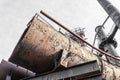 End of very large metal pipe, decaying industrial site