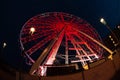 a ferris wheel illuminated in red color overview at night Royalty Free Stock Photo