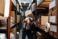 Endangered warehouse worker receiving a hit from the box falling off the shelf