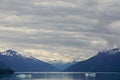 Endicott Arm, Alaska: Snow-capped mountains under a dramatic cloudy sky Royalty Free Stock Photo