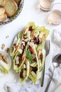 Endive leaves stuffed with cheese, walnuts, apple, radishes, honey and lime. Royalty Free Stock Photo