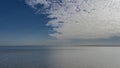 An endless blue ocean under an azure sky with picturesque white clouds.