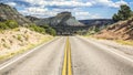 Endless empty road scenic Utah landscape with a sandstone mountain in the background