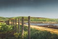 Endless fence of the countryside near the sea. Picturesque colorful landscape against mountains, sky and rural meadow Royalty Free Stock Photo