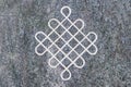 Endless knot engraved on stone surface.