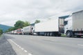 Endless line of transporting trucks standing one after another and waiting on the boarder for a permission for entrance