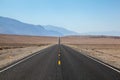 Endless and lonely blacktop road going into the mountain range entering Death Valley National Park Royalty Free Stock Photo